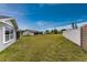 Large grassy backyard with new fence and other homes in the distance at 6375 Coniston St, Port Charlotte, FL 33981