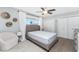 Bedroom with hardwood floors, a gray upholstered bed frame, and a large window with white curtains at 6375 Coniston St, Port Charlotte, FL 33981