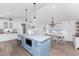 Open kitchen and dining area with blue island, white cabinetry, chandelier, creating a welcoming and stylish atmosphere at 6375 Coniston St, Port Charlotte, FL 33981