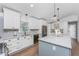 This open kitchen includes stainless appliances, white cabinets and a blue island with a white countertop at 6375 Coniston St, Port Charlotte, FL 33981
