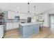 Open concept kitchen features a blue island with pendant lighting and white cabinets, perfect for cooking and entertaining at 6375 Coniston St, Port Charlotte, FL 33981