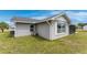 Rear exterior of single-story home with gray stucco, white trim, and small yard at 6375 Coniston St, Port Charlotte, FL 33981