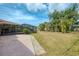 Well-maintained backyard with screened-in patio, mature trees, and landscaping at 7215 Brookhaven Ter, Englewood, FL 34224