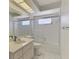 Bathroom with updated vanity sink, a toilet, and a tub with glass doors at 7215 Brookhaven Ter, Englewood, FL 34224