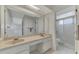 Bright bathroom featuring a double vanity sink with cabinet storage and large mirror at 7215 Brookhaven Ter, Englewood, FL 34224