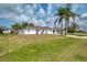Inviting home with a well-kept lawn, mature palm trees, and a concrete driveway at 7215 Brookhaven Ter, Englewood, FL 34224