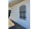 Exterior wall detail showing a decorative window with iron bars and gravel landscaping at 7215 Brookhaven Ter, Englewood, FL 34224