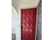 View of the front entrance with a solid red door with paneled details and a screen door at 7215 Brookhaven Ter, Englewood, FL 34224