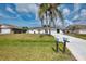 Charming single-story home with a well-maintained lawn and mature palm trees in a sunny, residential neighborhood at 7215 Brookhaven Ter, Englewood, FL 34224