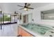 Enclosed tiled sunroom featuring a hot tub, ceiling fans, and a view to the backyard at 7215 Brookhaven Ter, Englewood, FL 34224