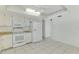 Neat and functional kitchen with white appliances, tile floors, and ample cabinet space at 7215 Brookhaven Ter, Englewood, FL 34224