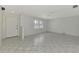 Bright living room featuring neutral tile flooring, ceiling fan, and large windows with plantation shutters at 7215 Brookhaven Ter, Englewood, FL 34224
