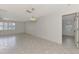 Bright and airy living room with tile flooring, a ceiling fan, and large windows at 7215 Brookhaven Ter, Englewood, FL 34224