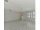Open-concept living room featuring neutral tile flooring, ceiling fan, and abundant natural light at 7215 Brookhaven Ter, Englewood, FL 34224