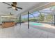 Screened-in pool area with a hot tub and a ceiling fan at 7215 Brookhaven Ter, Englewood, FL 34224