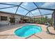 View of the enclosed pool area, hot tub, and patio in backyard with lush landscaping at 7215 Brookhaven Ter, Englewood, FL 34224