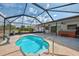 Pool view of lush tropical landscaping, and the kidney bean shaped pool with metal enclosure at 7215 Brookhaven Ter, Englewood, FL 34224