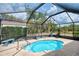 Enclosed pool area featuring a small pool with a metal frame enclosure and tropical landscaping at 7215 Brookhaven Ter, Englewood, FL 34224