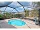 Enclosed kidney bean shaped pool, featuring a metal frame enclosure and tropical landscaping at 7215 Brookhaven Ter, Englewood, FL 34224
