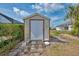 Backyard showing a storage shed with a wooden door and landscaping at 7215 Brookhaven Ter, Englewood, FL 34224