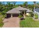 Aerial view showcasing the home's facade, landscaping, brick driveway, and meticulous lawn at 758 Rotonda Cir, Rotonda West, FL 33947