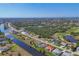 Expansive aerial view of a waterfront community with canals, lush greenery, and single-Gathering homes under a clear blue sky at 758 Rotonda Cir, Rotonda West, FL 33947