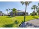Expansive backyard with lush landscaping and mature palms surrounding the screened lanai at 758 Rotonda Cir, Rotonda West, FL 33947