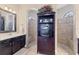 Stylish bathroom showcasing dual sinks, vanity, and two separate walk-in showers with a decorative cabinet at 758 Rotonda Cir, Rotonda West, FL 33947