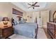 Comfortable bedroom features a ceiling fan, dark wood furniture, and a queen-size bed with plush bedding at 758 Rotonda Cir, Rotonda West, FL 33947