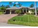 Inviting single-story home with a three-car garage, manicured lawn, and mature landscaping at 758 Rotonda Cir, Rotonda West, FL 33947