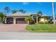 Beautiful single-story home featuring a three-car garage, manicured lawn, and elegant landscaping at 758 Rotonda Cir, Rotonda West, FL 33947