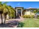 Charming home featuring a brick walkway, manicured landscaping, and a welcoming front entrance with double doors at 758 Rotonda Cir, Rotonda West, FL 33947