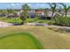 Scenic view of a golf course green featuring a flag, surrounded by palm trees, well-manicured lawns, and luxury homes at 758 Rotonda Cir, Rotonda West, FL 33947