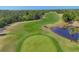 Beautiful aerial view of golf course with rolling green fairways, golf carts, and a serene pond at 758 Rotonda Cir, Rotonda West, FL 33947