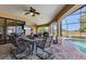 Enclosed lanai with an outdoor dining area overlooking the pool, golf course, and lush landscaping at 758 Rotonda Cir, Rotonda West, FL 33947