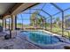 Screened-in patio with a serene pool and lush landscaping creates a private oasis at 758 Rotonda Cir, Rotonda West, FL 33947