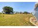 Expansive backyard featuring lush green grass and a well-maintained community landscape at 816 Tangerine Woods Blvd, Englewood, FL 34223