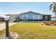 Inviting single-story mobile home with a carport, lush lawn and flourishing tropical flowers at 816 Tangerine Woods Blvd, Englewood, FL 34223