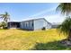 Charming single-story home with blue siding, complemented by a screened lanai and lush green lawn at 816 Tangerine Woods Blvd, Englewood, FL 34223