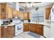 Well-lit kitchen features light wood cabinets, white appliances, and modern light fixture at 816 Tangerine Woods Blvd, Englewood, FL 34223