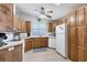 Bright kitchen features wood cabinets, white appliances, and a window over the sink at 816 Tangerine Woods Blvd, Englewood, FL 34223