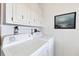 Functional laundry area featuring a washer and dryer with overhead cabinet storage at 816 Tangerine Woods Blvd, Englewood, FL 34223