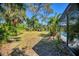 A spacious backyard with lush landscaping and mature trees for shade at 850 Van Gogh Road, Englewood, FL 34223