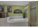 Modern bathroom with a soaking tub, glass-enclosed shower, and stylish tile accents at 850 Van Gogh Road, Englewood, FL 34223