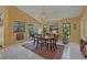 Cozy dining area with a modern light fixture, large windows, and access to the backyard at 850 Van Gogh Road, Englewood, FL 34223