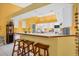 Bright and cheery kitchen with a white island, cabinetry and bar stool seating at 850 Van Gogh Road, Englewood, FL 34223