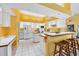 The kitchen has white tile, appliances and cabinets, with a breakfast bar and views to the dining area at 850 Van Gogh Road, Englewood, FL 34223