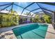Spacious pool area with covered lanai and tropical landscaping at 850 Van Gogh Road, Englewood, FL 34223