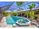 Inviting screened-in pool and spa area with lounge chairs and tropical landscaping at 850 Van Gogh Road, Englewood, FL 34223
