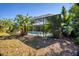 The backyard features a pool and a screened enclosure surrounded by lush plants at 850 Van Gogh Road, Englewood, FL 34223